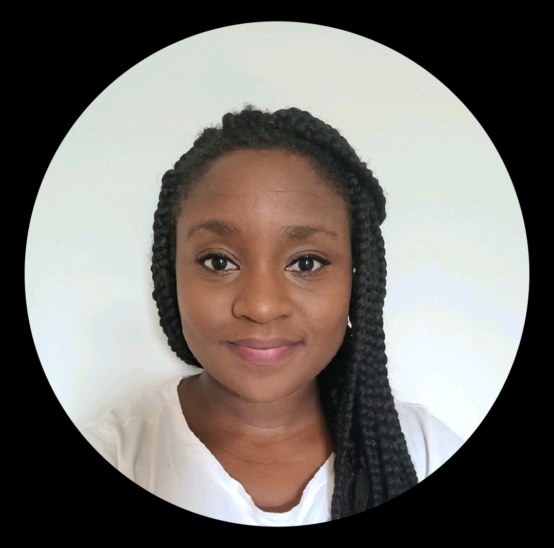 Professional headshot of a woman with braided hair, subtle makeup, and white top against a light background.